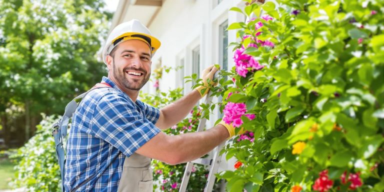 Contractor working on a sunny house exterior.